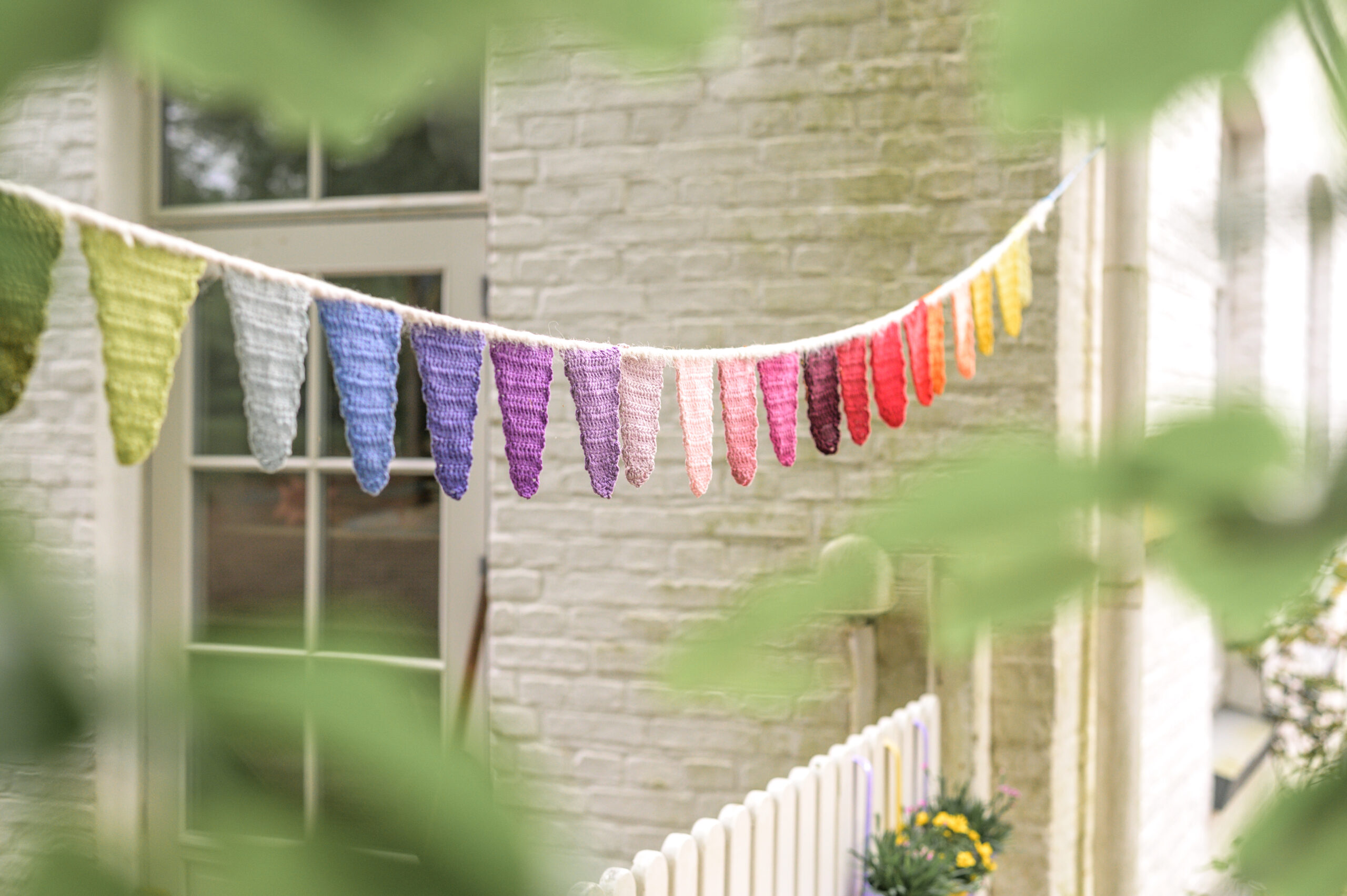 bunte Girlande im Garten und vor dem Haus des Walddorfkindergartens in Gluecksburg