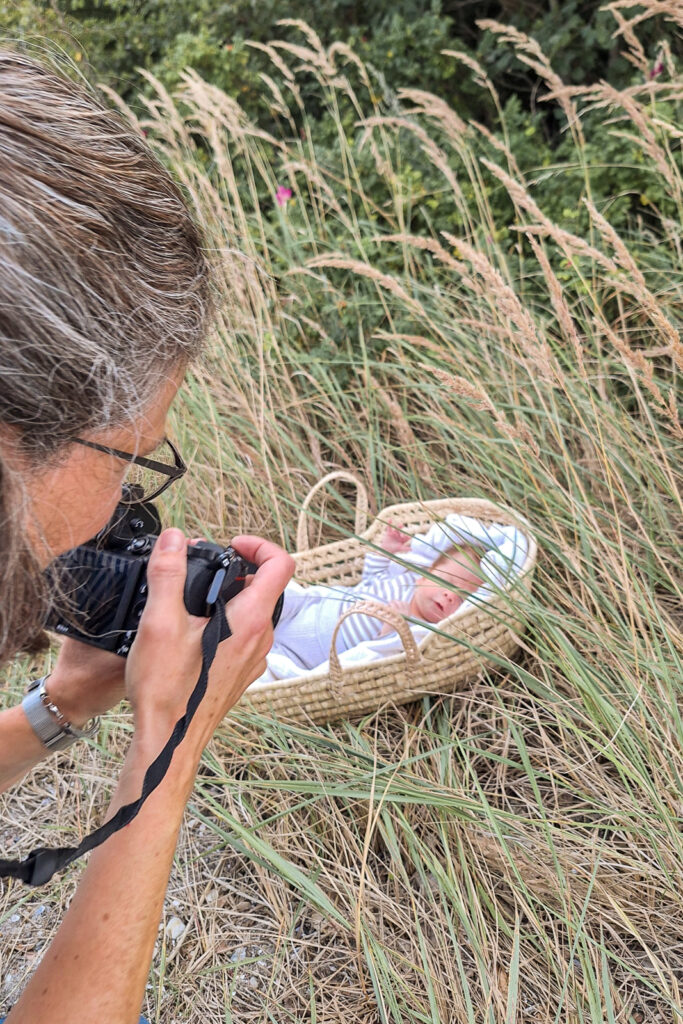 Neugeborenen Fotografin in Flensburg Glücksburg und Umgebung fotografiert Baby im Körbchen am Strand in der Natur.