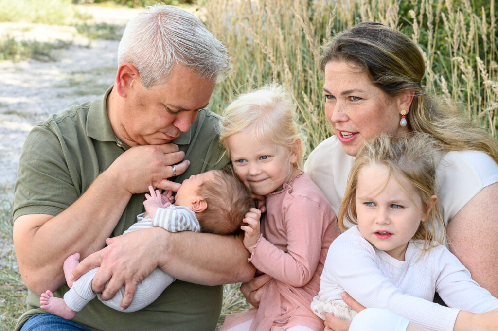 fuenfkoepfige Familie im Sommer am Strand an der Flensburger Förde in hellen Farben nah beieinander