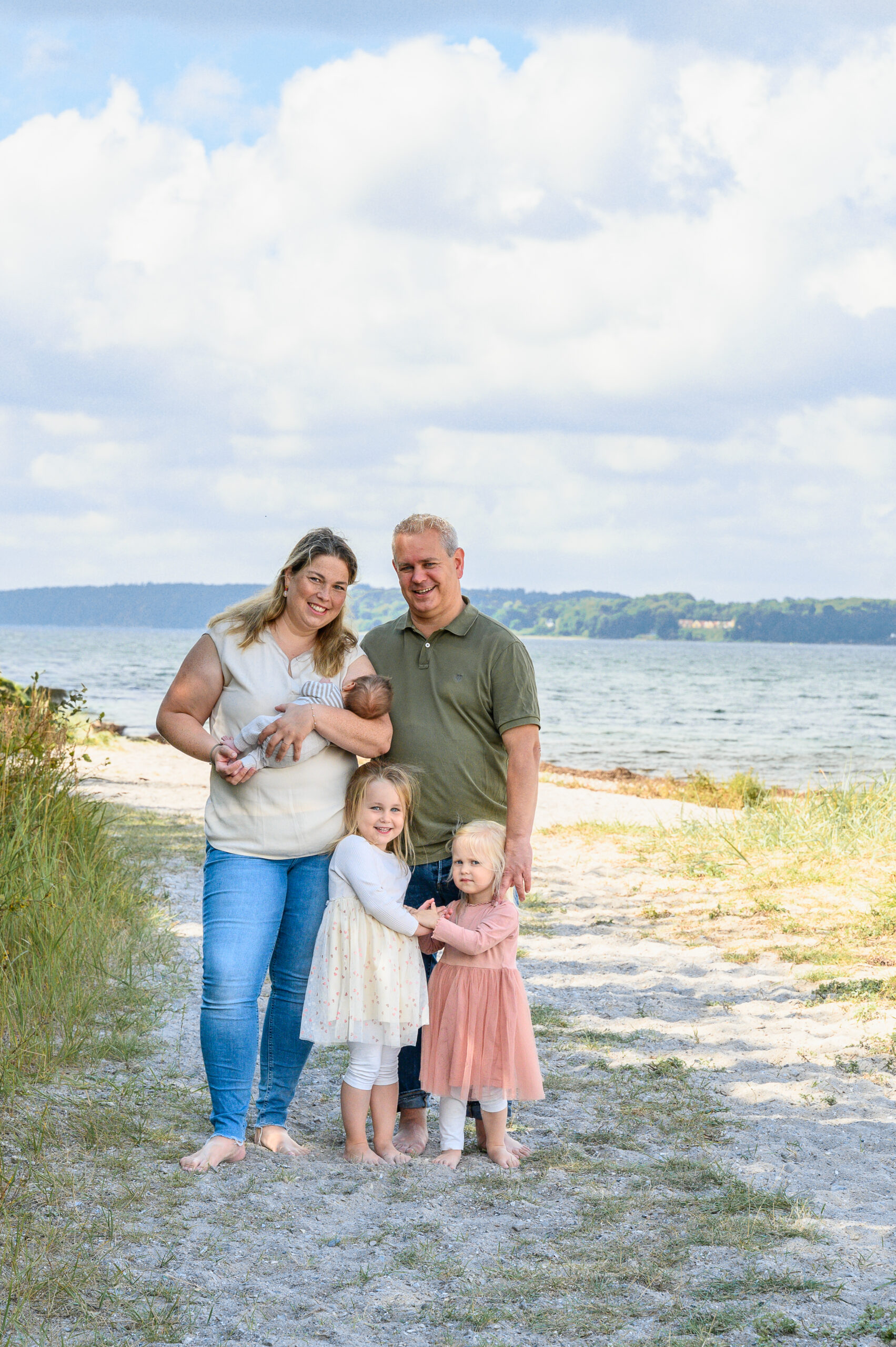 Familienfoto stehend zu fuenft barfuss am Strand in Gluecksburg