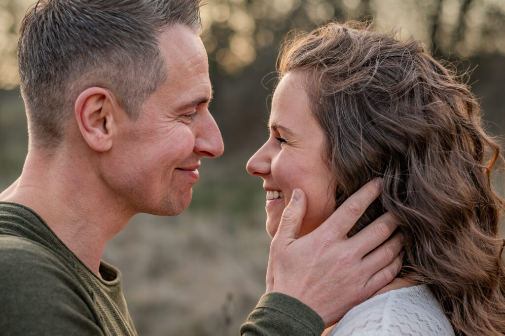 Inniger und laechelnder Blick der werdenden Eltern im Profil aufgenommen beim Schwangerschaftsshootig in Flensburg von Annette Kleinschmidt.