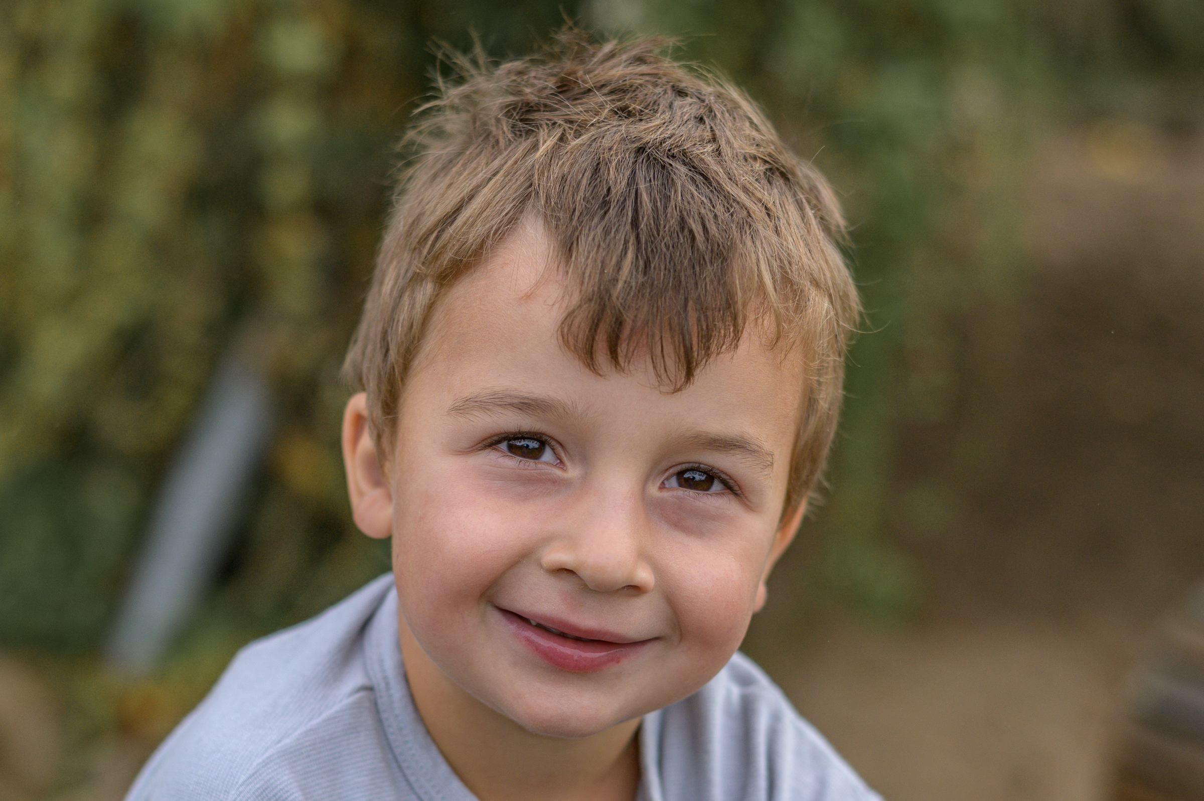 Kita Junge mit verwuschelten Haaren und neugierigem Blick