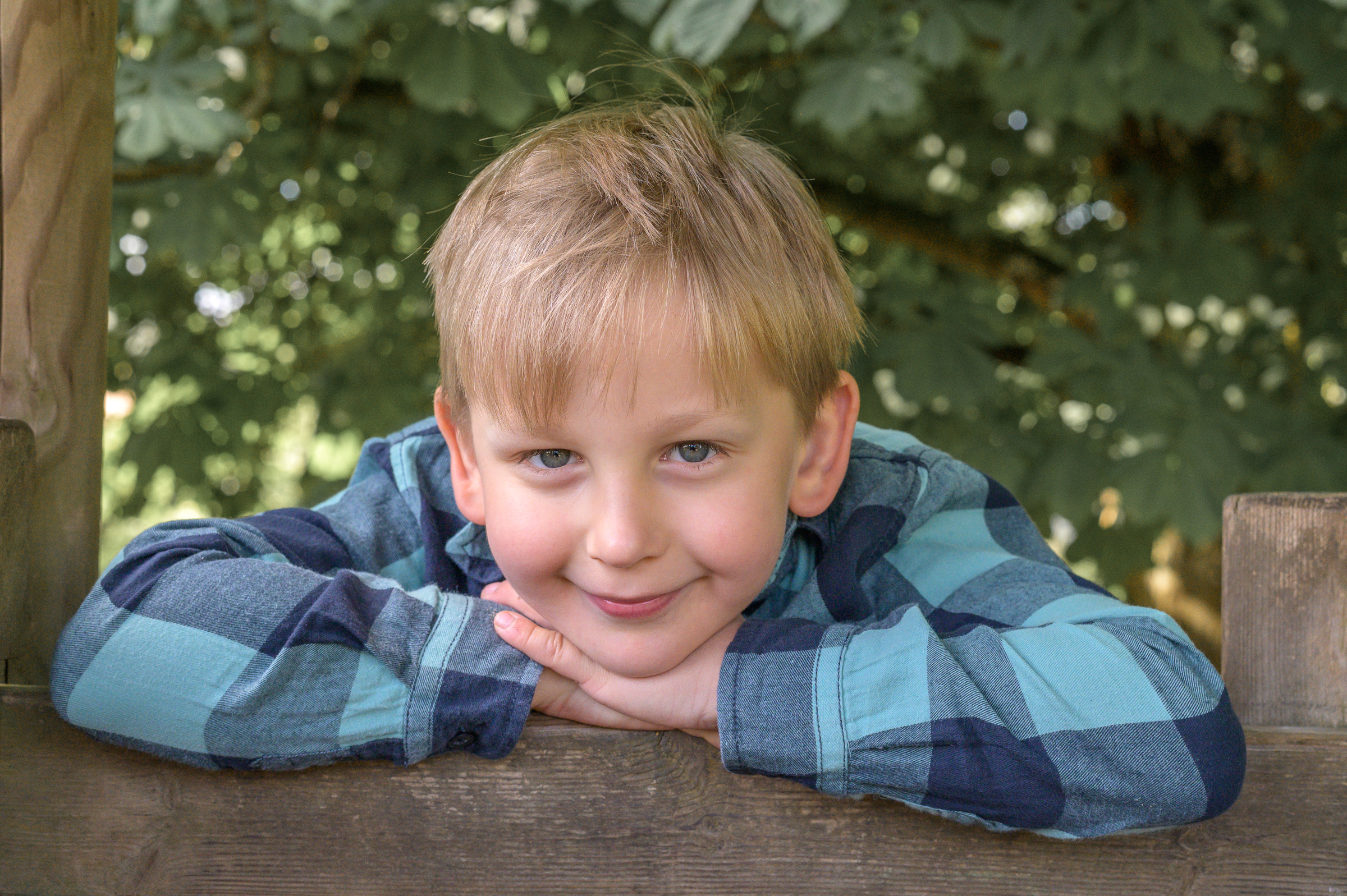 Grosses Kita Kind aus Flensburg guckt vom Klettergeruest entspannt in die Kamera.