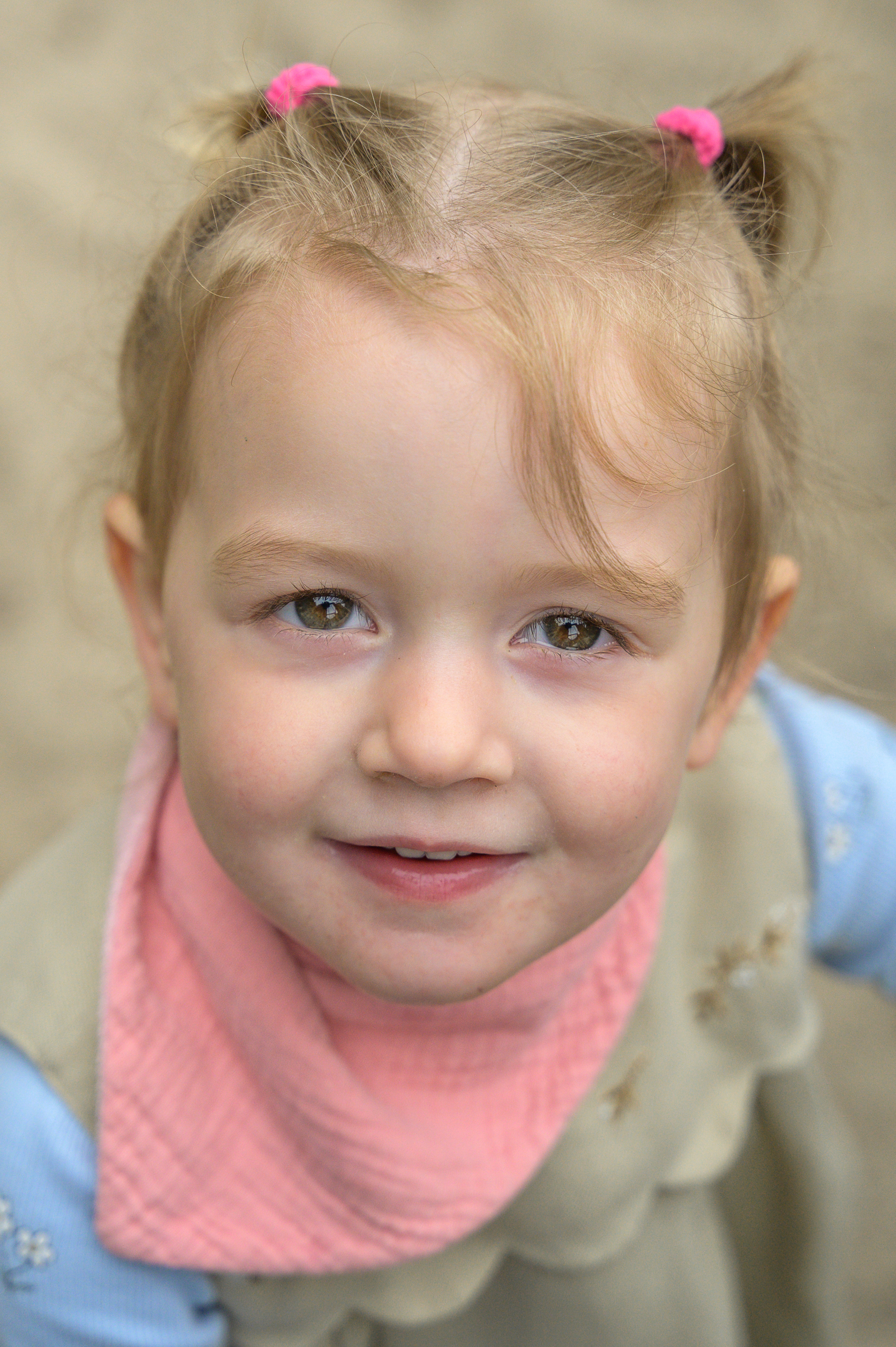 Krippenkind guckt neugierig in die Foto Kamera und es entsteht ein sehr natürliches Porträtfoto.